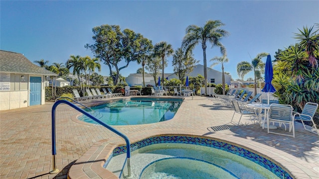 view of swimming pool with a patio area and a hot tub