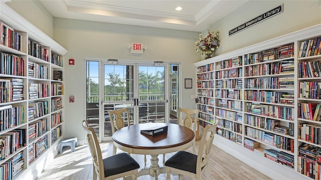 sitting room featuring a raised ceiling and light hardwood / wood-style flooring