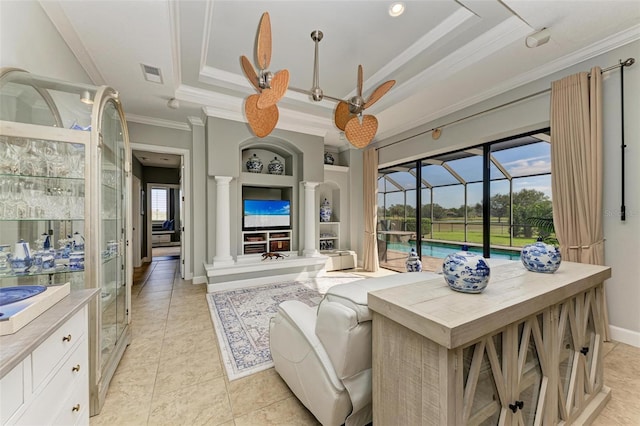 tiled living room with crown molding, decorative columns, a raised ceiling, and built in shelves