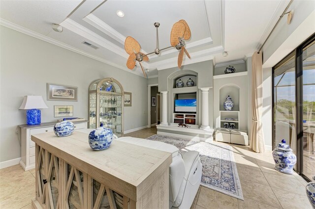 living room with decorative columns, ornamental molding, light tile patterned floors, a tray ceiling, and built in shelves