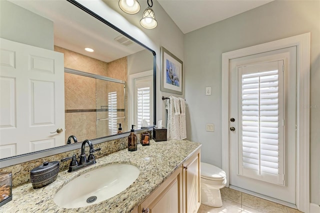 bathroom featuring vanity, toilet, tile patterned floors, and walk in shower