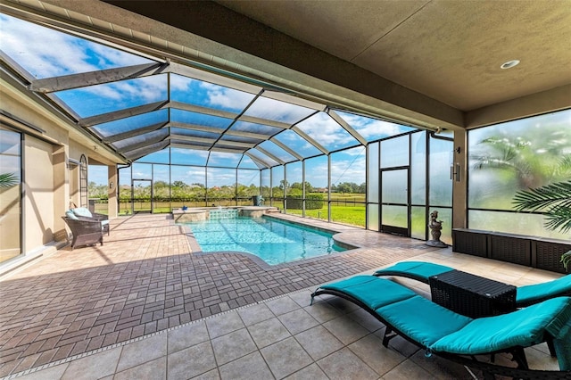 view of pool featuring an in ground hot tub, a patio, and glass enclosure