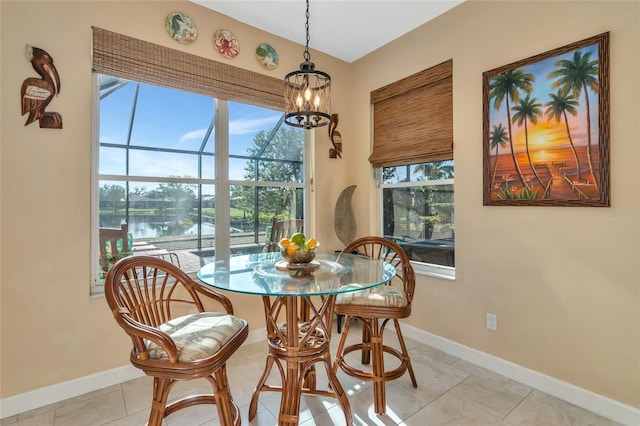 tiled dining room featuring a notable chandelier, plenty of natural light, and a water view