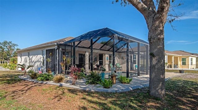 rear view of property with a lanai, a lawn, and a pool