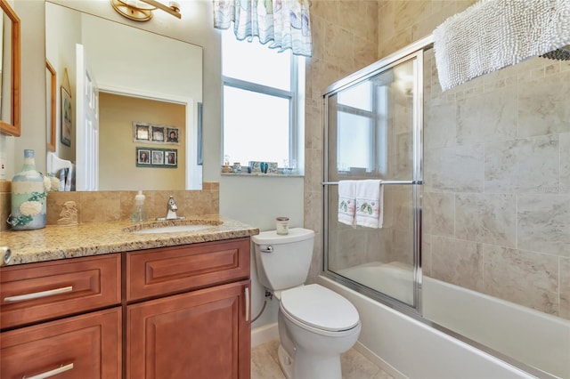 full bathroom with combined bath / shower with glass door, vanity, and toilet