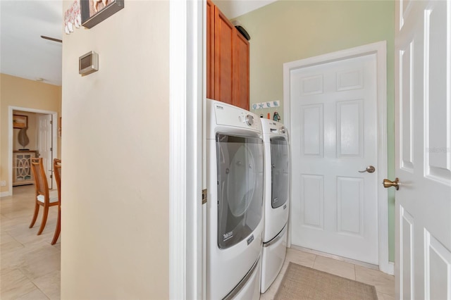 washroom with cabinets, washer and clothes dryer, and light tile patterned flooring