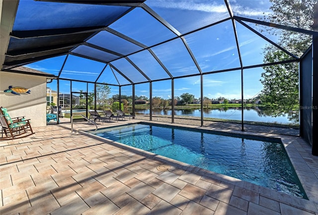 view of swimming pool featuring glass enclosure, a water view, and a patio