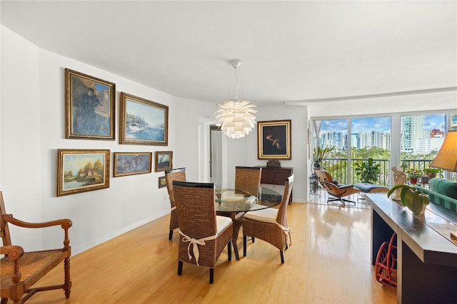 dining room with light wood-type flooring and a notable chandelier