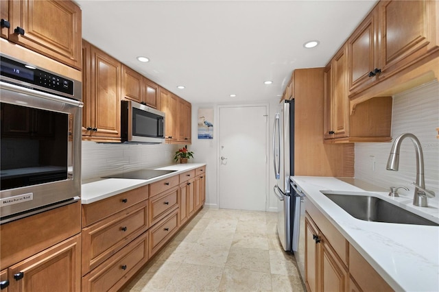 kitchen with light stone countertops, sink, appliances with stainless steel finishes, and tasteful backsplash