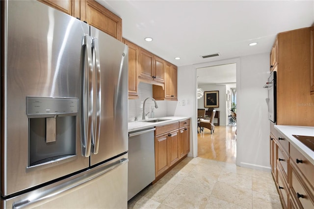 kitchen with stainless steel appliances, decorative backsplash, and sink