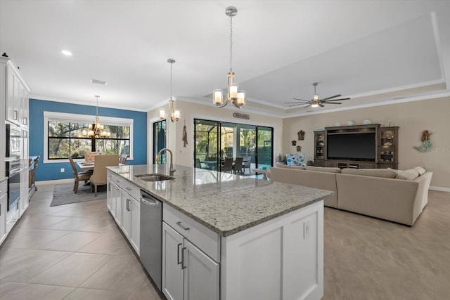 kitchen with white cabinetry, sink, an island with sink, decorative light fixtures, and ceiling fan with notable chandelier