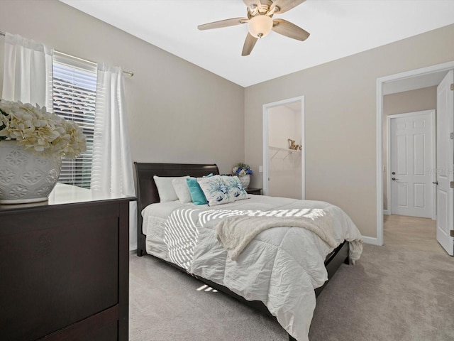 carpeted bedroom featuring a closet, a spacious closet, and ceiling fan