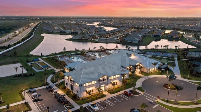 aerial view at dusk featuring a water view