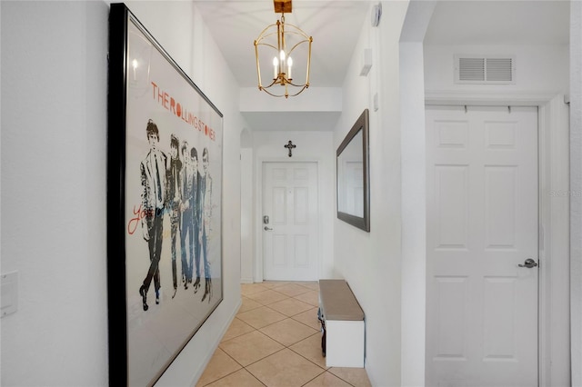 corridor with a notable chandelier and light tile patterned flooring