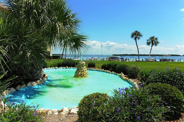 view of swimming pool featuring a water view and a yard