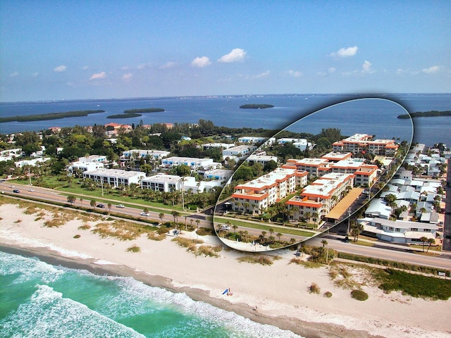 birds eye view of property featuring a water view and a beach view