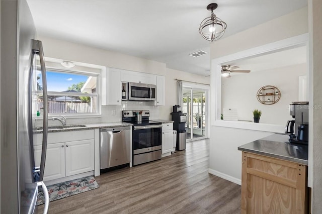 kitchen featuring ceiling fan, sink, stainless steel appliances, decorative light fixtures, and white cabinets