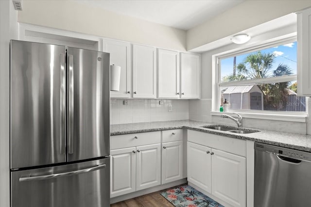 kitchen featuring light stone countertops, white cabinetry, sink, and stainless steel appliances