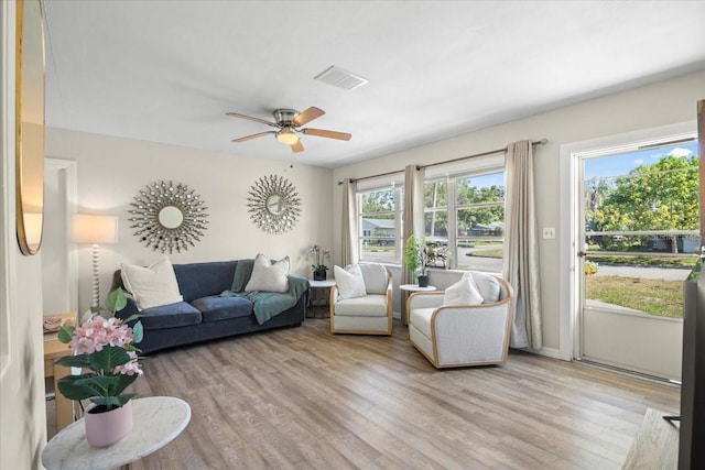 living room with light wood-type flooring and ceiling fan