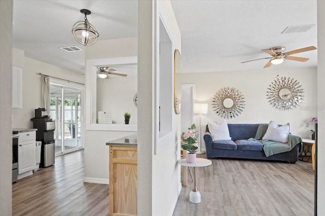 living room featuring ceiling fan and light hardwood / wood-style floors