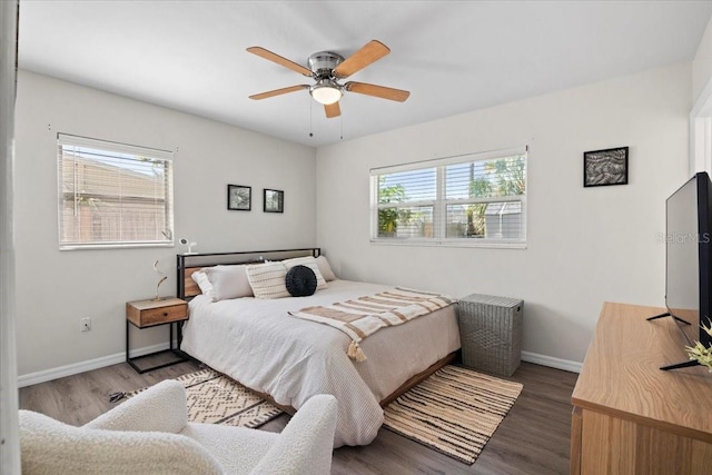 bedroom with multiple windows, ceiling fan, and dark hardwood / wood-style flooring