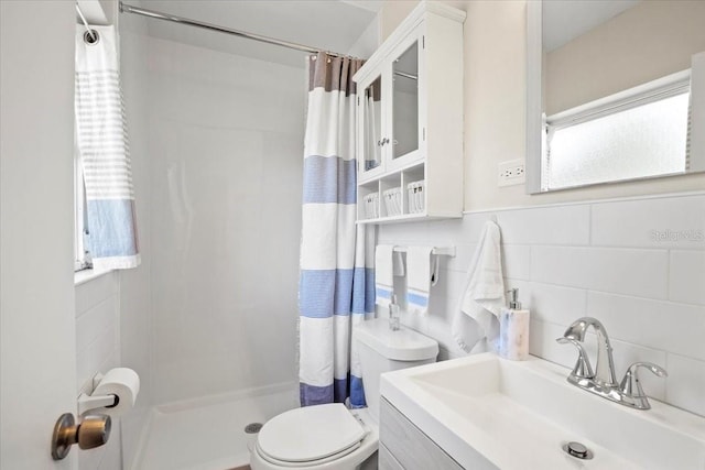 bathroom featuring curtained shower, toilet, tile walls, and a wealth of natural light