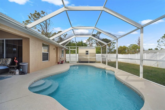 view of swimming pool featuring a patio, a storage unit, and a lawn