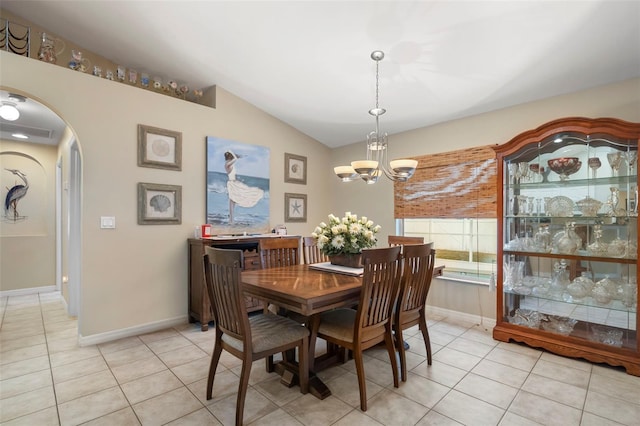 tiled dining space featuring lofted ceiling and a notable chandelier