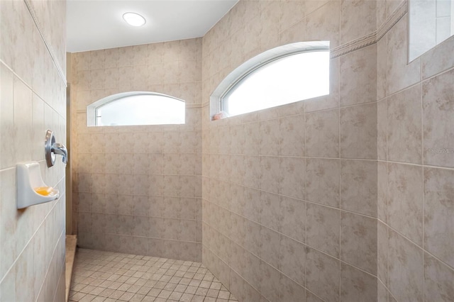 bathroom featuring a tile shower and a wealth of natural light