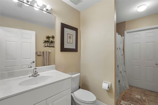 bathroom featuring vanity, tile patterned floors, and toilet