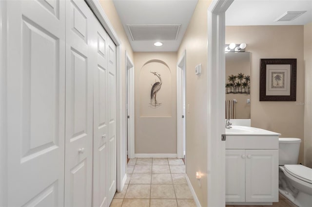 hall featuring light tile patterned floors and sink