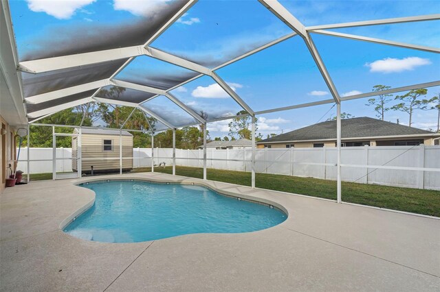 view of swimming pool featuring a patio, a yard, and a shed