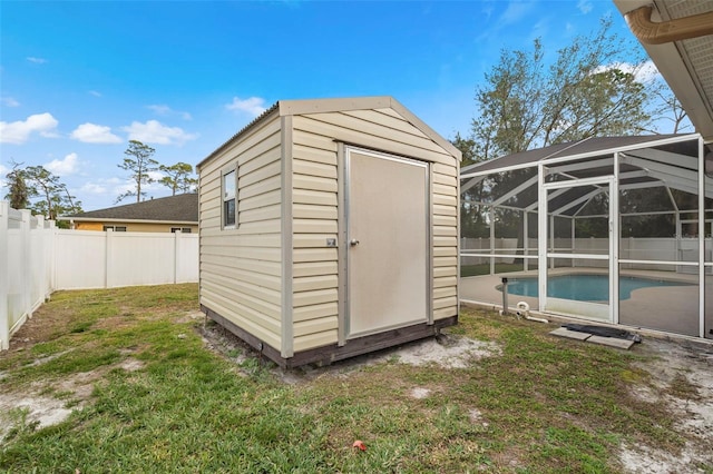 view of outdoor structure featuring a fenced in pool and a lawn