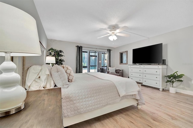 bedroom with a textured ceiling, access to exterior, ceiling fan, and light hardwood / wood-style floors