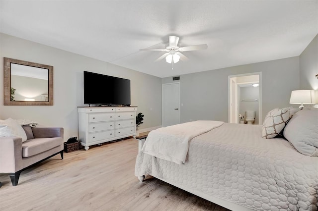 bedroom with ensuite bathroom, ceiling fan, and light hardwood / wood-style flooring