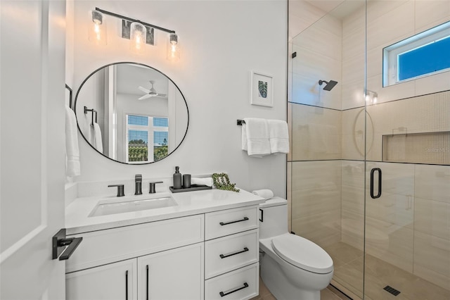 bathroom featuring ceiling fan, vanity, a shower with shower door, and toilet