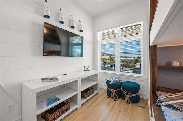 bedroom featuring wood walls and light hardwood / wood-style flooring