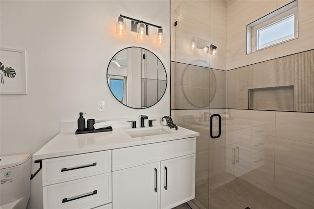 bathroom with vanity, toilet, and a shower with shower door