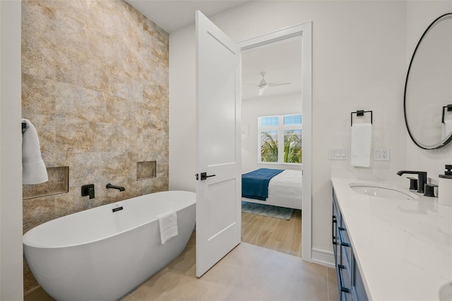 bathroom with vanity, a tub to relax in, and ceiling fan