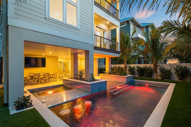 pool at dusk featuring a patio area