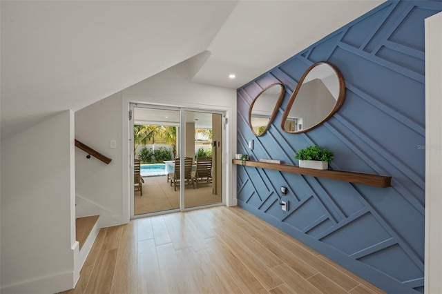 entryway featuring wood-type flooring and vaulted ceiling