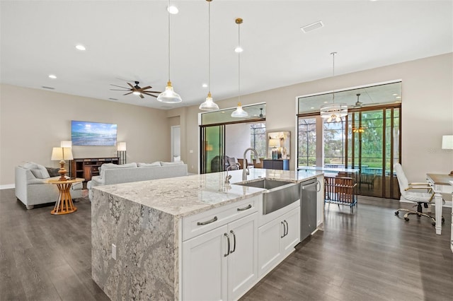 kitchen featuring white cabinetry, a center island with sink, decorative light fixtures, dishwasher, and light stone countertops