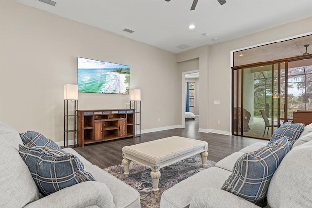 living room featuring dark wood-type flooring and ceiling fan