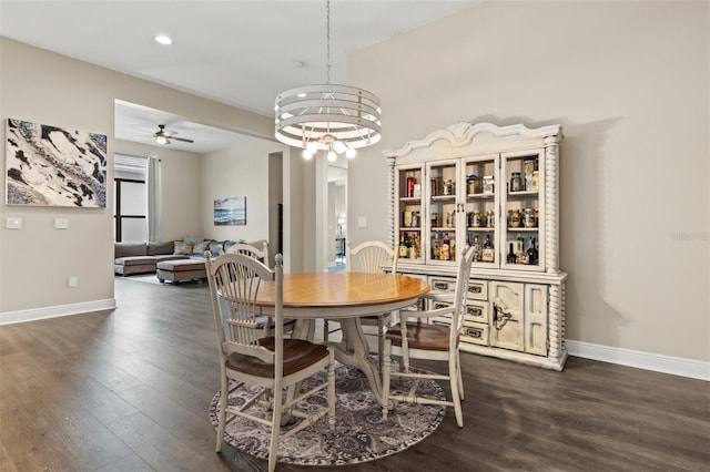 dining area with dark hardwood / wood-style floors and ceiling fan with notable chandelier