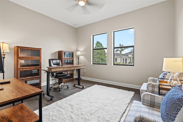 home office with ceiling fan and dark hardwood / wood-style flooring