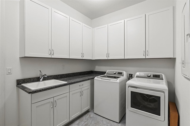 washroom featuring cabinets, sink, and washing machine and clothes dryer