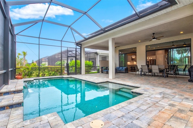 view of swimming pool featuring glass enclosure, ceiling fan, a patio area, an outdoor hangout area, and pool water feature