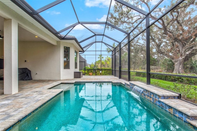 view of pool with pool water feature, a patio, and glass enclosure