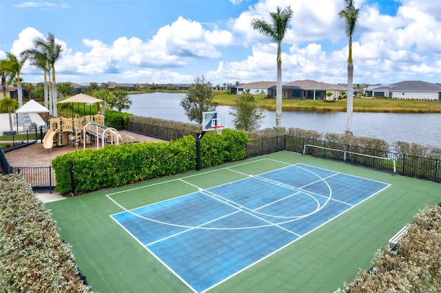 view of sport court with a playground and a water view