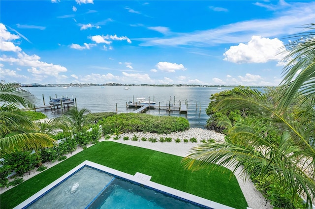 view of swimming pool with a boat dock, a yard, and a water view